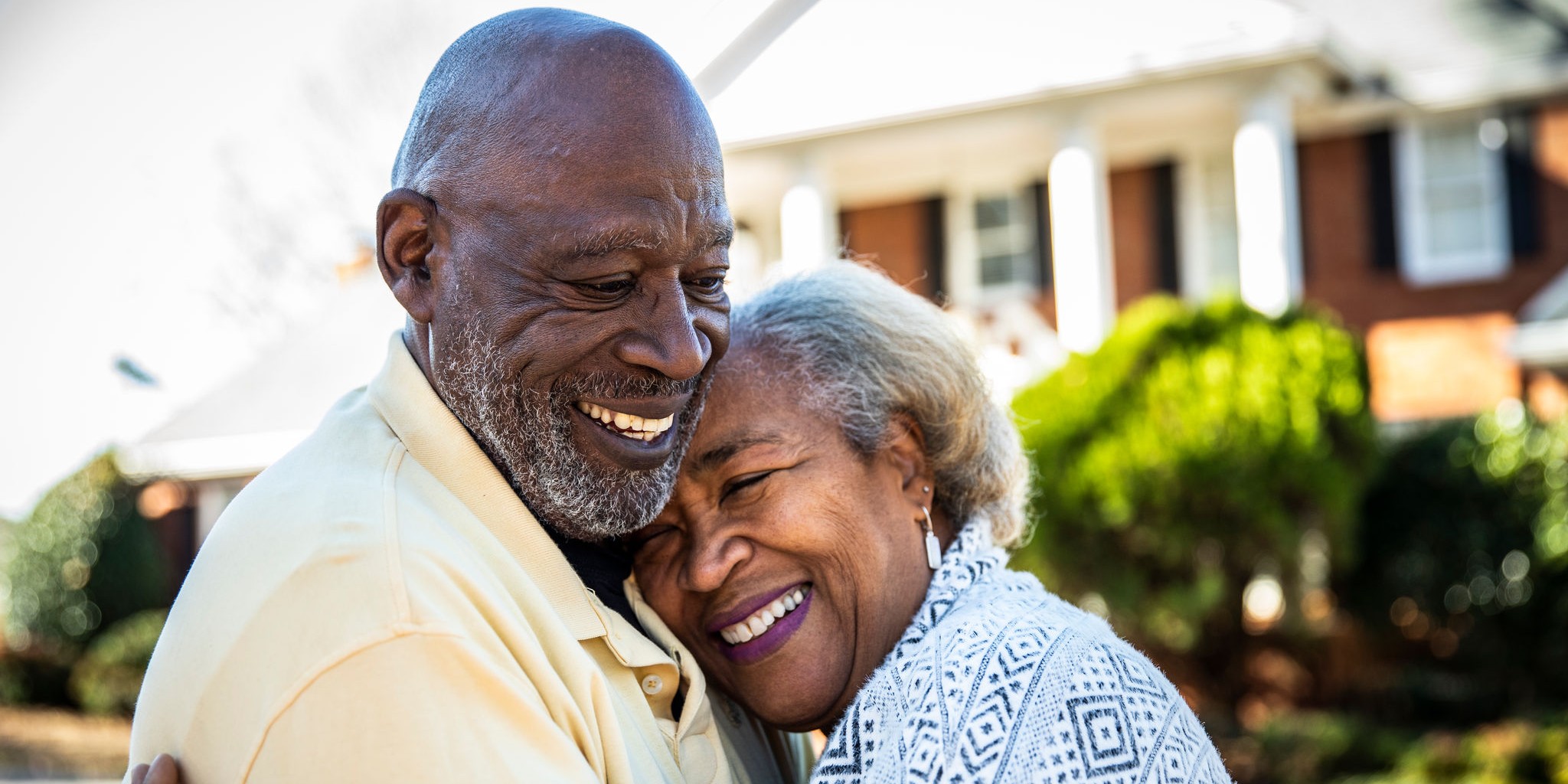 couple hugging in front of home